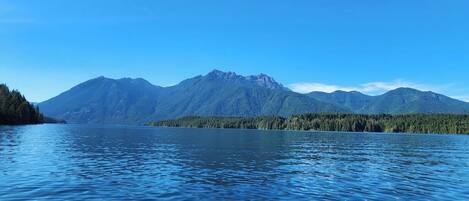 Un lago tranquilo con montañas al fondo.