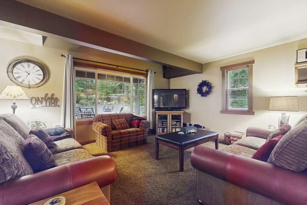 Una sala de estar con sofás de cuero, una mesa de centro, un televisor y una chimenea.
