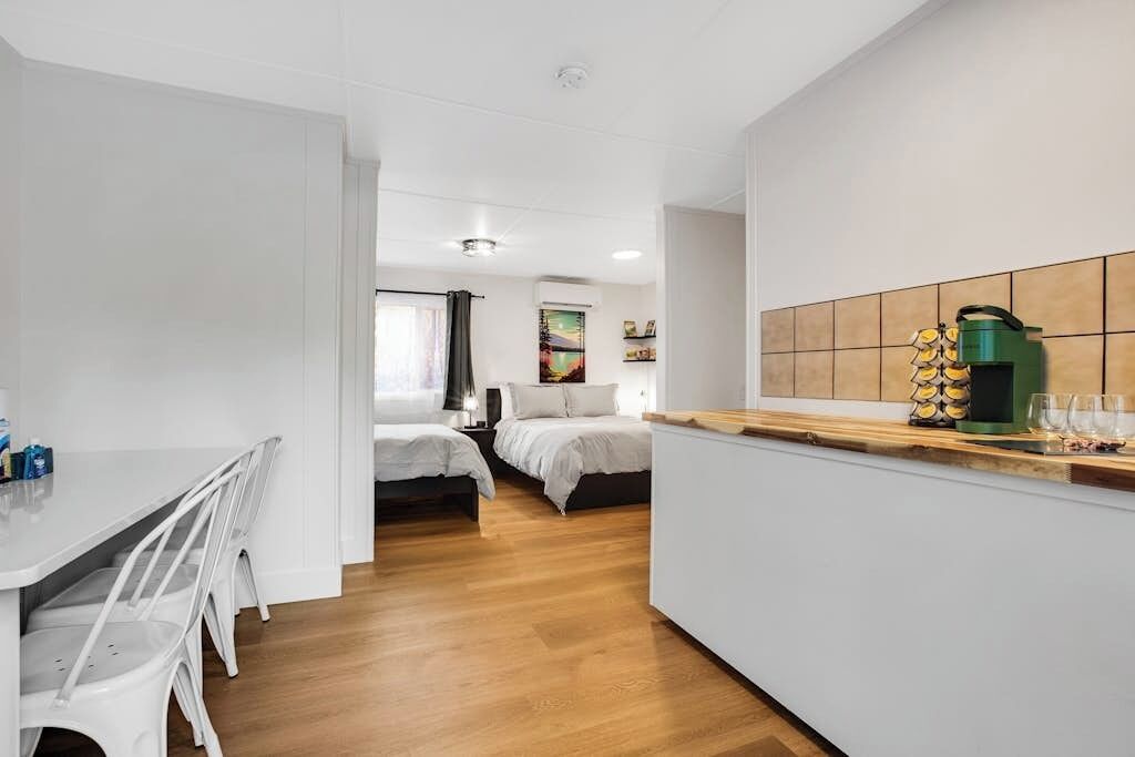Une chambre d’hôtel compacte comprenant un coin cuisine, un espace repas et un lit.