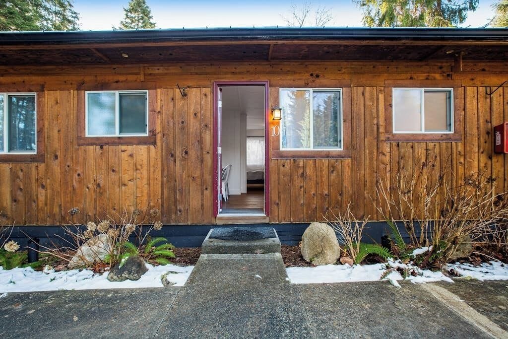 Une cabane en bois avec une porte d’entrée, deux fenêtres et une plaque portant le numéro « 10 ».