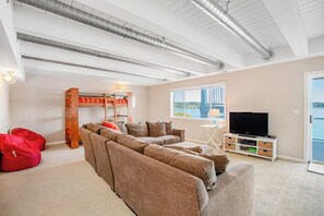 Una sala de estar moderna con un sofá modular, un televisor de pantalla plana y un amplio ventanal con vistas.