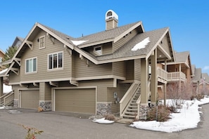 Ein zweigeschossiges Haus mit Garage, Treppe und Balkon.