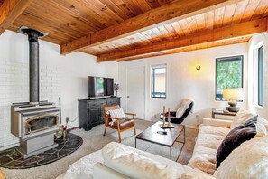 A cozy living room with a fireplace, comfortable seating, and a television. - 4BR - Sauna - WoodStove - Balcony - Firepit - Washer Dryer (Snoqualmie Pass)