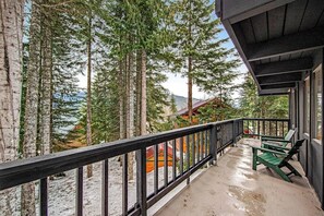A balcony with a view of tall trees and a distant building. - 4BR - Sauna - WoodStove - Balcony - Firepit - Washer Dryer (Snoqualmie Pass)