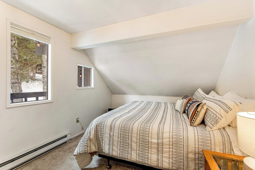Ein Schlafzimmer mit Bett, Fenster und Heizung.