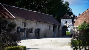 A building with a dirt courtyard, a small tower, and an arched entrance.