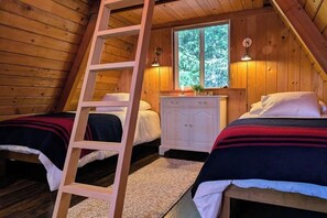 A cabin with two beds, a wooden ladder, a window, and a white dresser. - Rare cabin with deck, fire pit (Ronald)