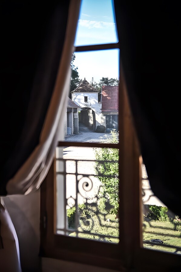 A window with a view of a building and a garden.