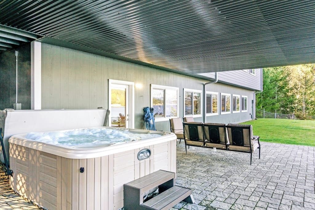 Ein Whirlpool, Sitzmöglichkeiten im Freien und eine überdachte Terrasse.