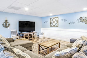 A living room with a flat-screen TV, wooden coffee table, and patterned sofas. - 4BR Waterview Dog Friendly - Hot Tub - Deck (Union)