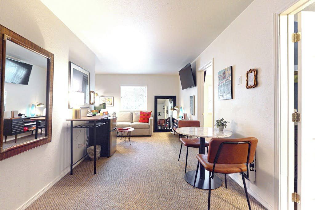 A compact living space with a kitchenette, a dining area, and a sofa.