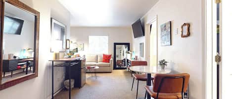 A compact living space with a kitchenette, a dining area, and a sofa.