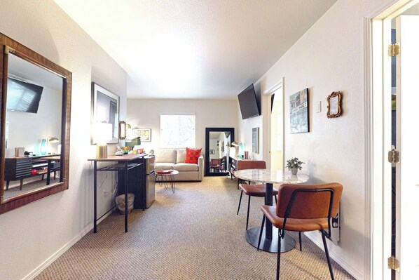 A compact living space with a kitchenette, a dining area, and a sofa.