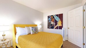 A hotel room with a large bed, a bedside table with a lamp, a wall-mounted artwork, and a closed door. - 1BR Hotel Room right in Downtown Port Townsend (Port Townsend)