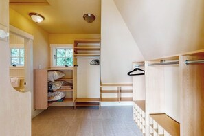 Een gang met een houten kast, een raam en een deur.