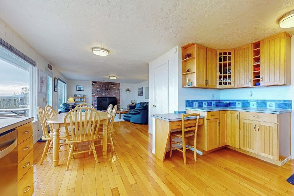 A spacious kitchen with wooden cabinets and a dining area with a table and chairs.