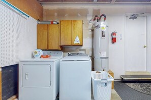 A laundry area with two washing machines, a dryer, and a fire extinguisher. - 3 BR beachfront cabin with private hot tub (Sequim)