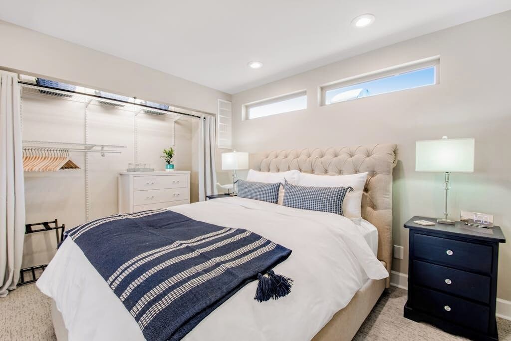 A bedroom with a large bed, bedside tables, a wardrobe, and a window.