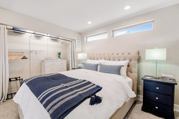 A bedroom with a large bed, bedside tables, a wardrobe, and a window.