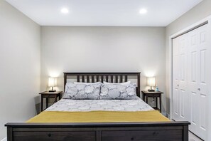 Ein Schlafzimmer mit einem Bett, zwei Nachttischen und einem Kleiderschrank.