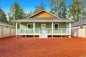 Eingeschossiges Haus mit Veranda, Eingangstür und kleinem Vorgarten.