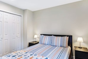 A bedroom with a bed, two bedside tables, and a wardrobe. - Elegant 3BR Dog Friendly - Deck - Washer Dryer (Westport)