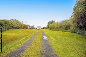 A rural property with a gravel driveway leading to a house, surrounded by greenery. - 3BR Oceanfront Dog Friendly - Deck (Ocean Shores)