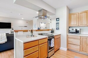 A modern kitchen with wooden cabinets, a built-in oven, and a microwave.