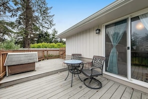 A covered patio with a table and chairs, a bench, and a sliding glass door. - 2BR Dog Friendly - Dock - Deck - Foosball - Washer Dryer (Westport)