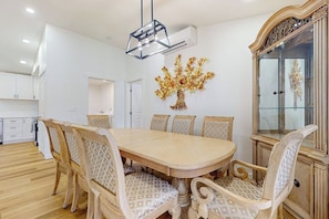 A dining area with a large wooden table surrounded by patterned chairs, a decorative wall piece, and a classic cabinet. - 2 BR Home right on the lake with grill, fire pit (Cle Elum)
