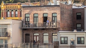 Un edificio de varios pisos con un balcón en el segundo nivel.