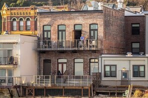 A multi-story building with a balcony on the second floor. - Studio Room w/ Water Views overlooking The Bay (Port Townsend)