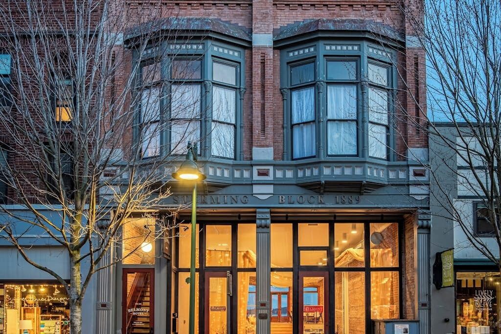 A corner building with a bay window, a sign reading 'Sterning Block 1889,' and a visible entrance to a hotel.