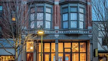 A corner building with a bay window, a sign reading 'Sterning Block 1889,' and a visible entrance to a hotel.