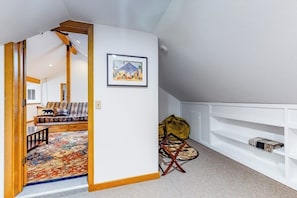 A room with a wooden bench, a framed picture, a yellow bag, and a white shelving unit. - 4BR Bayview Dog Friendly - Deck - Garage Parking (Port Ludlow)