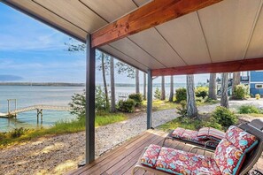 A covered outdoor seating area with a view of a lake and a bridge. - 2BR family friendly getaway with deck, Washer Dryer, Wifi (Fox Island)