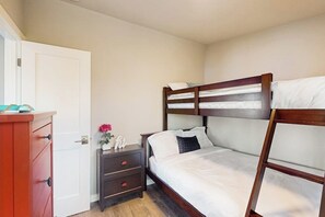 A bedroom with a bunk bed, a bedside table with a lamp, and a wardrobe. - 2BR family friendly getaway with deck, Washer Dryer, Wifi (Fox Island)