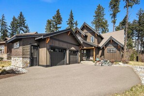 Ein zweistöckiges Haus mit Garage, überdachter Veranda und Auffahrt.