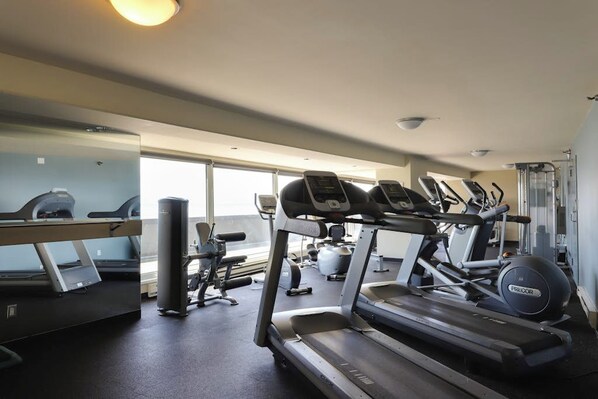 A gym with treadmills, elliptical machines, and weight equipment. - 1BR condo near attractions with pool & hot tub (Seattle)