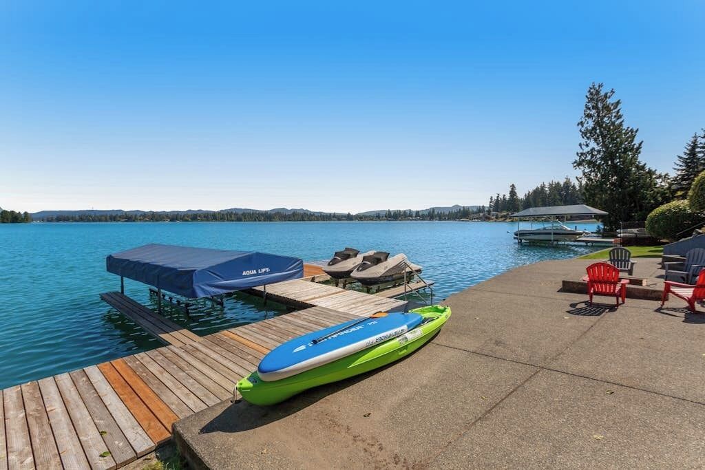 Une jetée avec un kayak vert, un espace de repos abrité et une vue dégagée sur le lac.