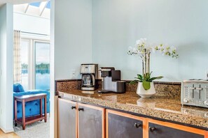 A kitchen with a coffee maker, toaster, and a potted plant.