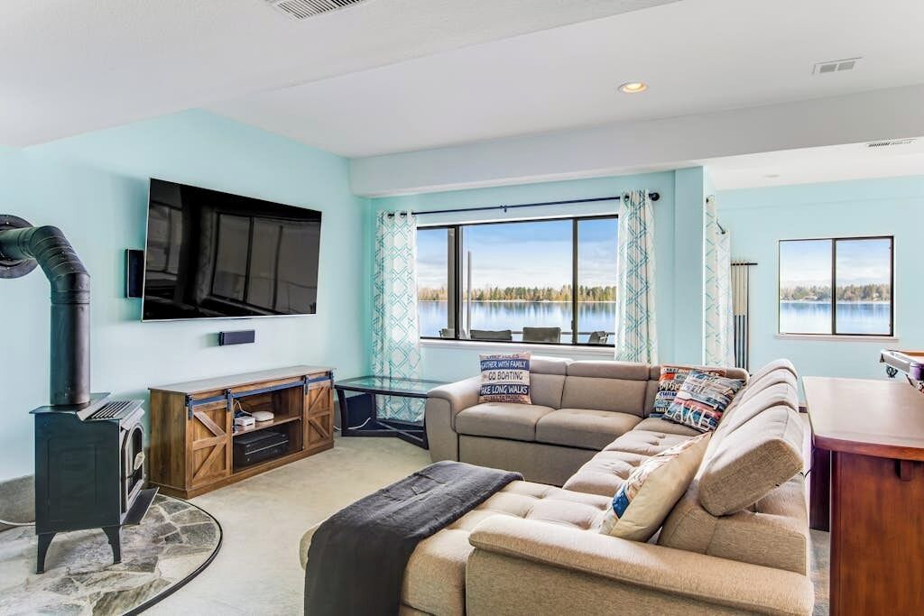 A living room with a large window, a fireplace, a sofa, and a television.
