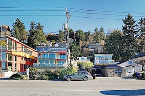 A multi-story building with a modern design, a parking area, and a car parked in front. - Original 3BR - Dog Friendly - Amazing Bay Views (Seattle)