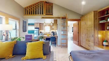 A spacious living area with a loft bedroom, a kitchen, and a dining area.