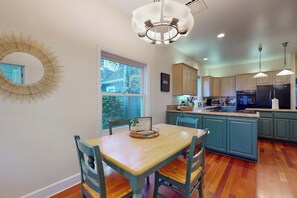 A kitchen with teal cabinetry, a wooden dining table, and a chandelier. - Elegant 3BR Dog Friendly - Patio - Pool Table (Seattle)