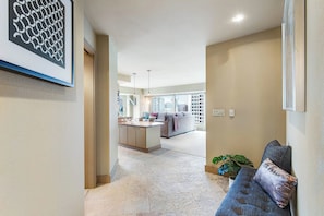 A hallway leading to a living area with a sofa and a dining area with a table and chairs. - 2BR modern home with amazing views, pool & hot tub (Seattle)
