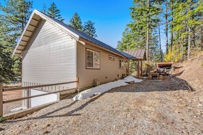 A single-story building with a sloped roof, a covered porch, and a gravel driveway. - Custom 3BR - Balcony - Washer Dryer (Ronald)