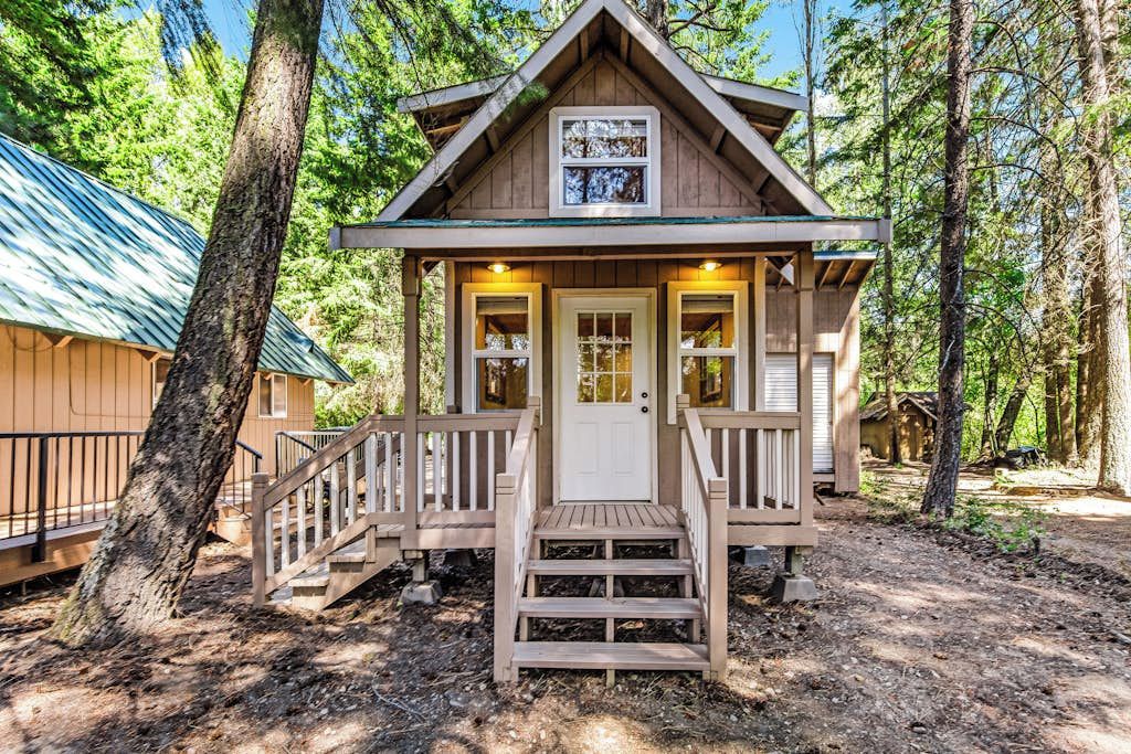 A small cabin with a front porch, a door, and a window.