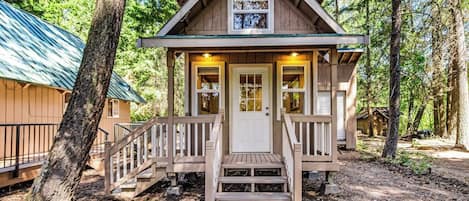 A small cabin with a front porch, a door, and a window.