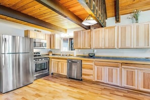 A modern kitchen with stainless steel appliances, wooden cabinets, and a herringbone floor pattern. - 2BR lakefront cabin with private dock (Cle Elum)